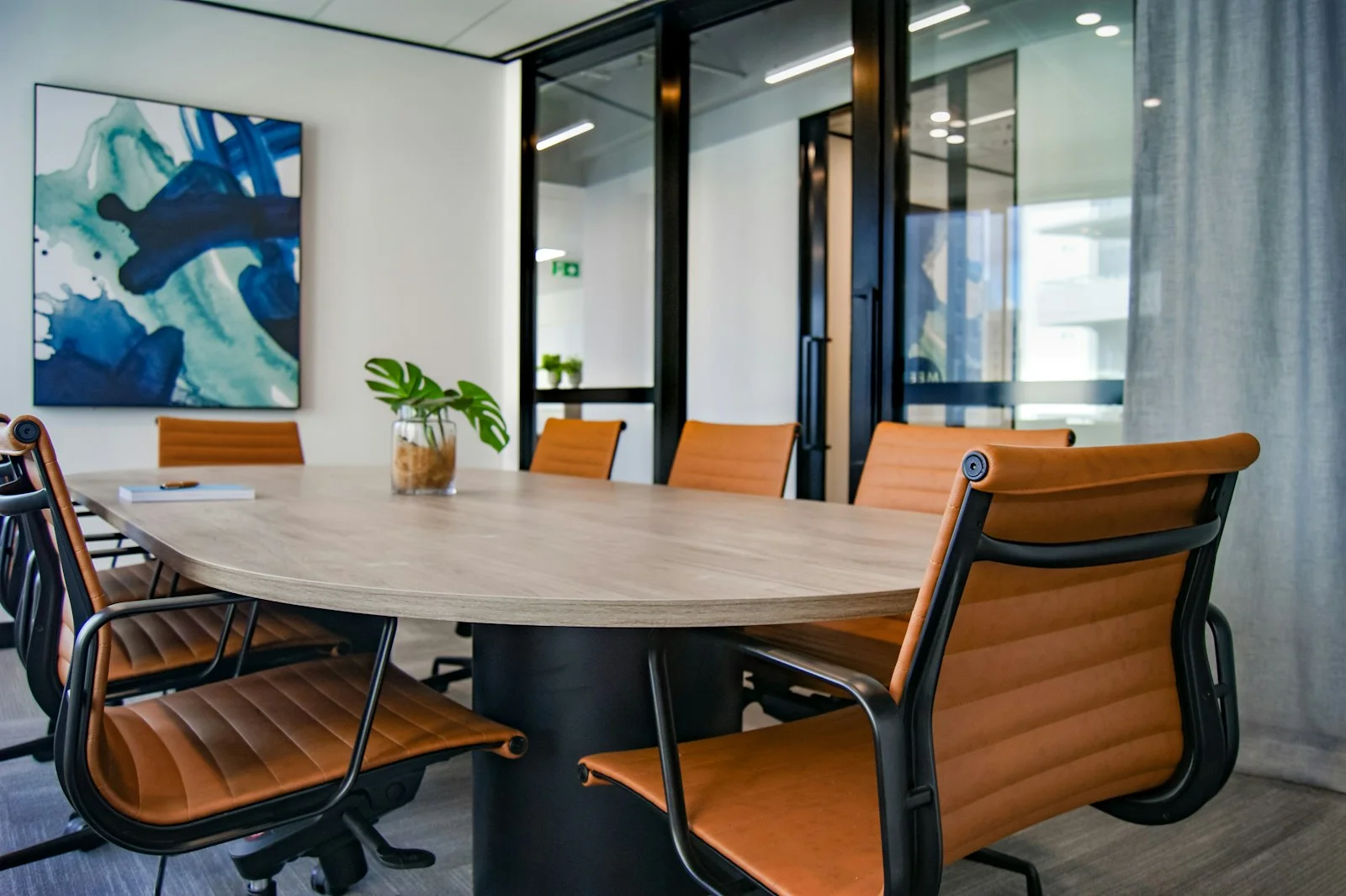 A calm Australian office with an empty meeting table, notebooks and morning light through the windows, no people and no writing on screen or wall.